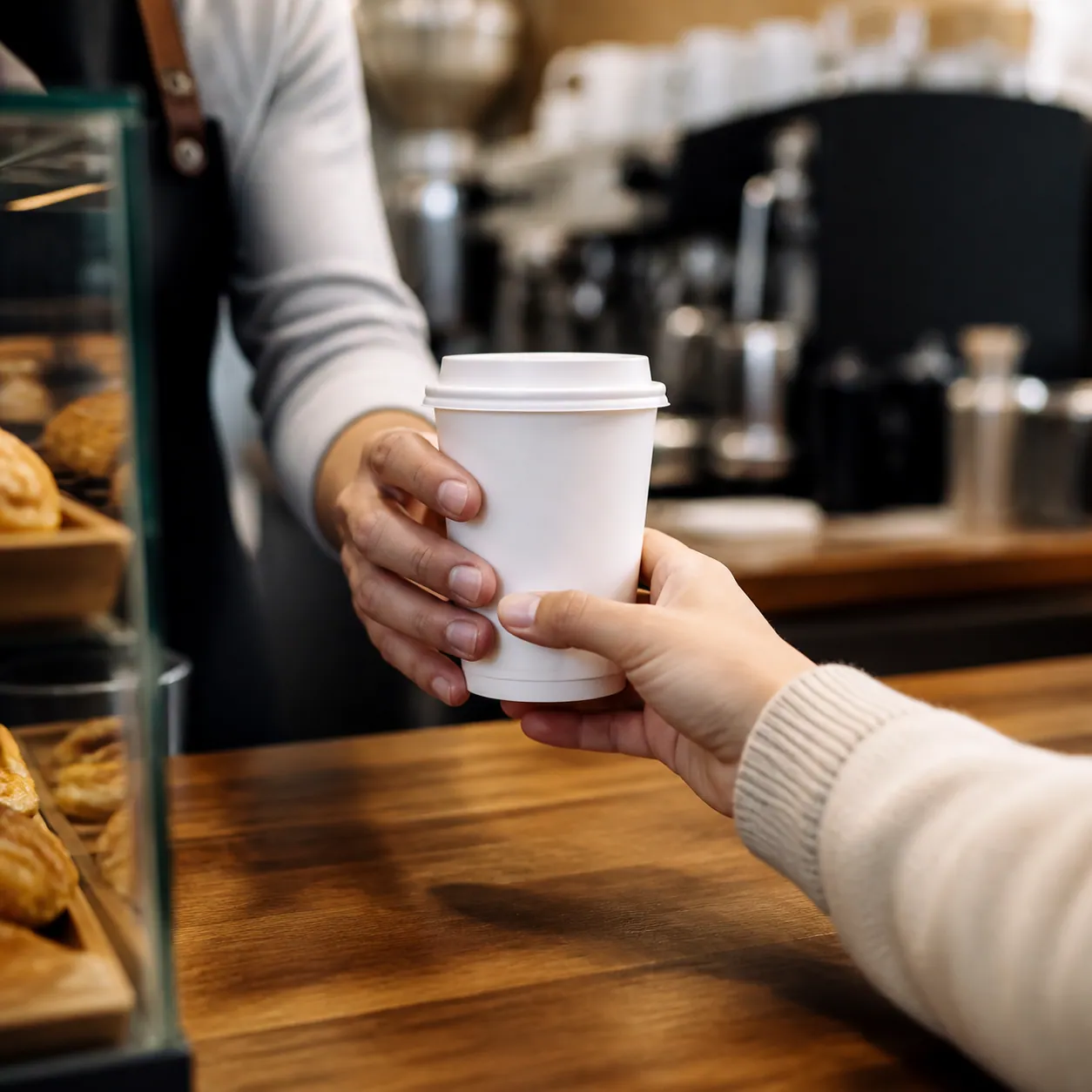 A takeaway cup handed across the counter